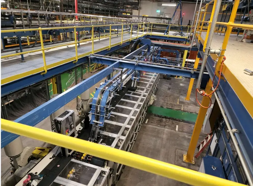 Elevated steel platforms with yellow handrails and blue support beams around industrial production equipment